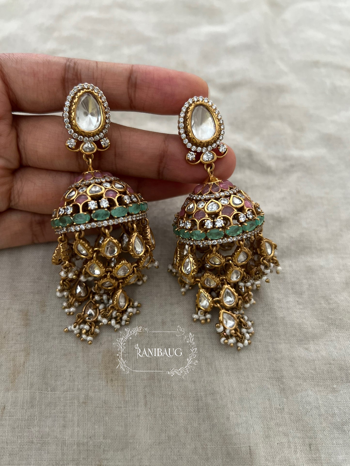 Aaravi Polki Fall Premium Gold Finish Emerald Stones And Pearl Adorned Jhumka Earrings By Ranibaug