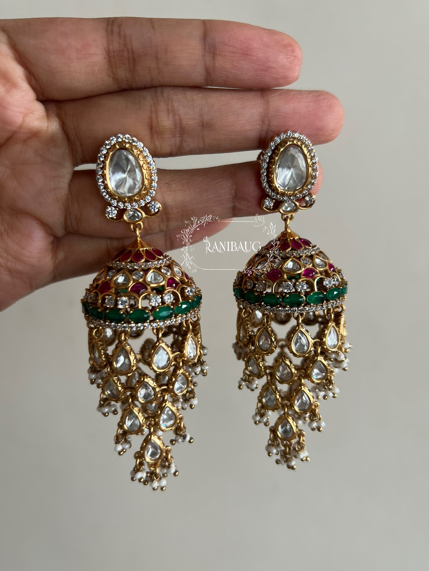 Aaravi Polki Fall Premium Gold Finish Emerald Stones And Pearl Adorned Jhumka Earrings By Ranibaug