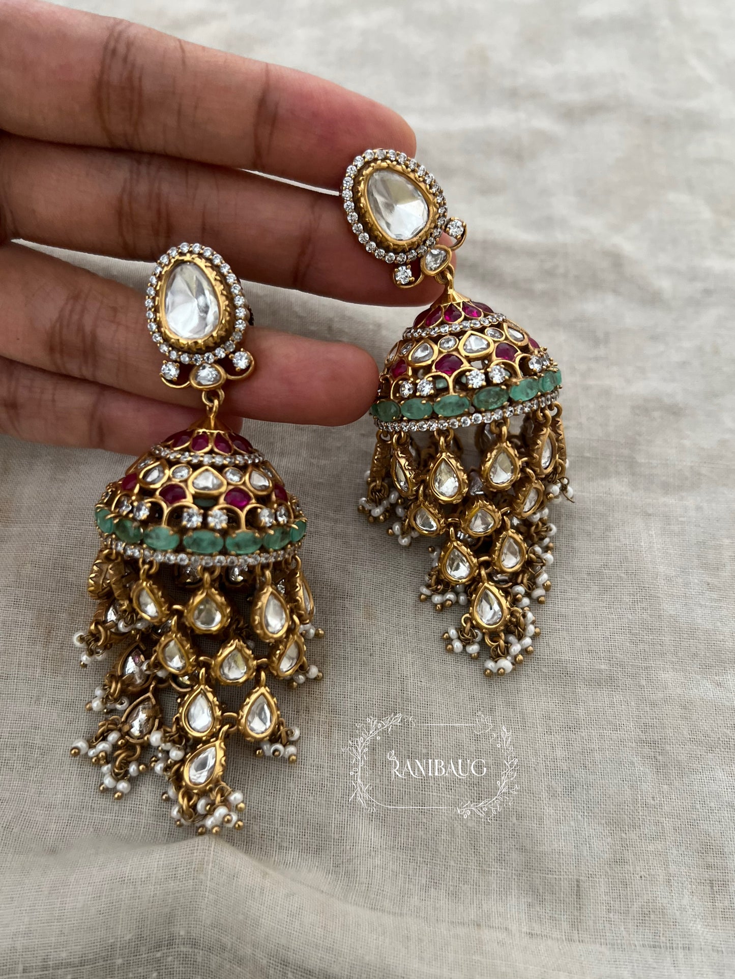 Aaravi Polki Fall Premium Gold Finish Emerald Stones And Pearl Adorned Jhumka Earrings By Ranibaug