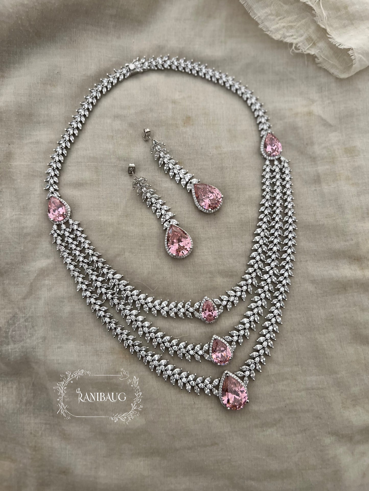 Bansi Layered Designer Diamond Necklace Jewelry Set By Ranibaug Adorned With Emerald And Pink Teardrop Stones