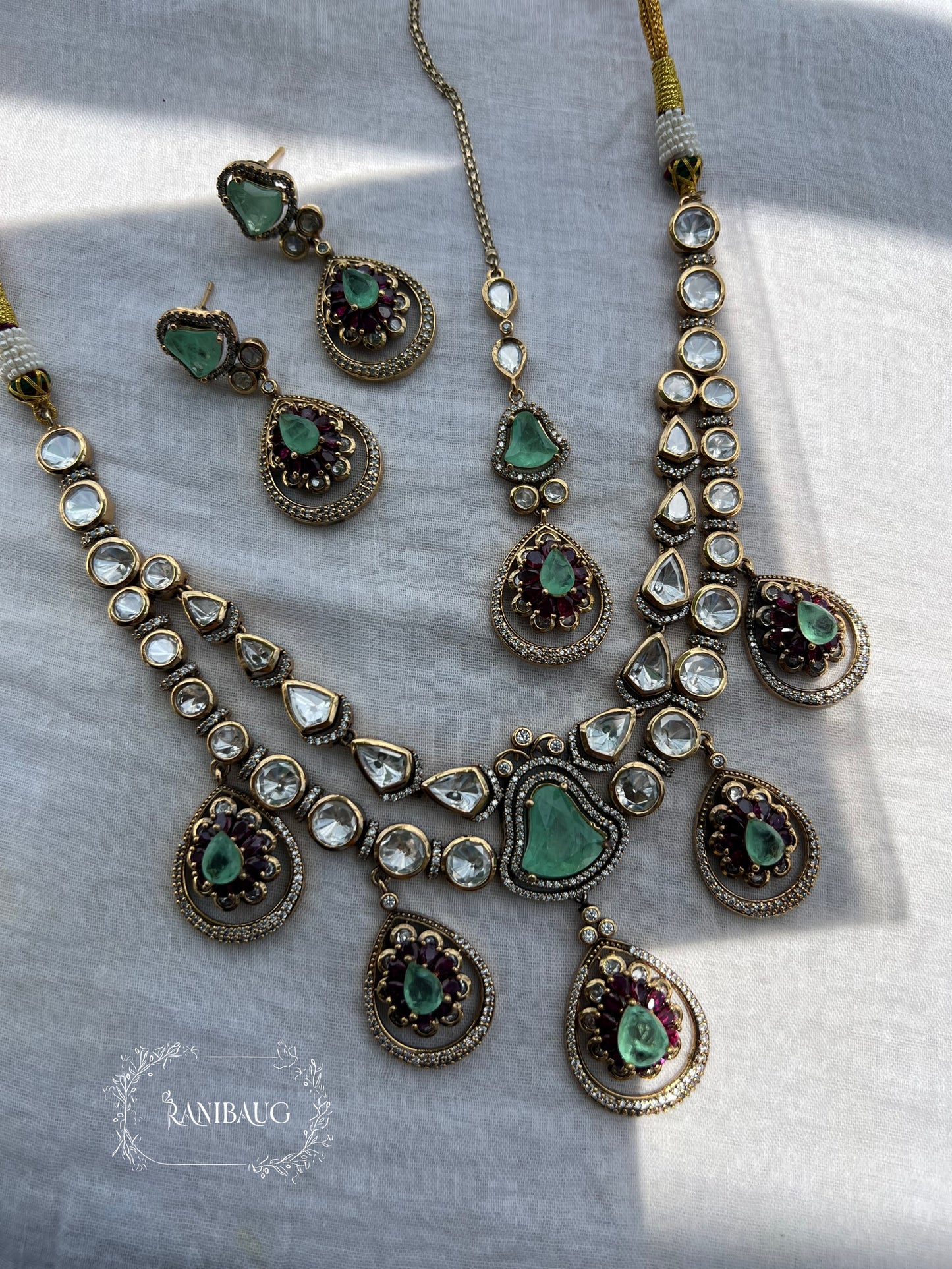 Kiyana Polki Gemstone Adorned Teardrop Dangle Motifs Layered Royal Necklace With Maang Tikka By Ranibaug