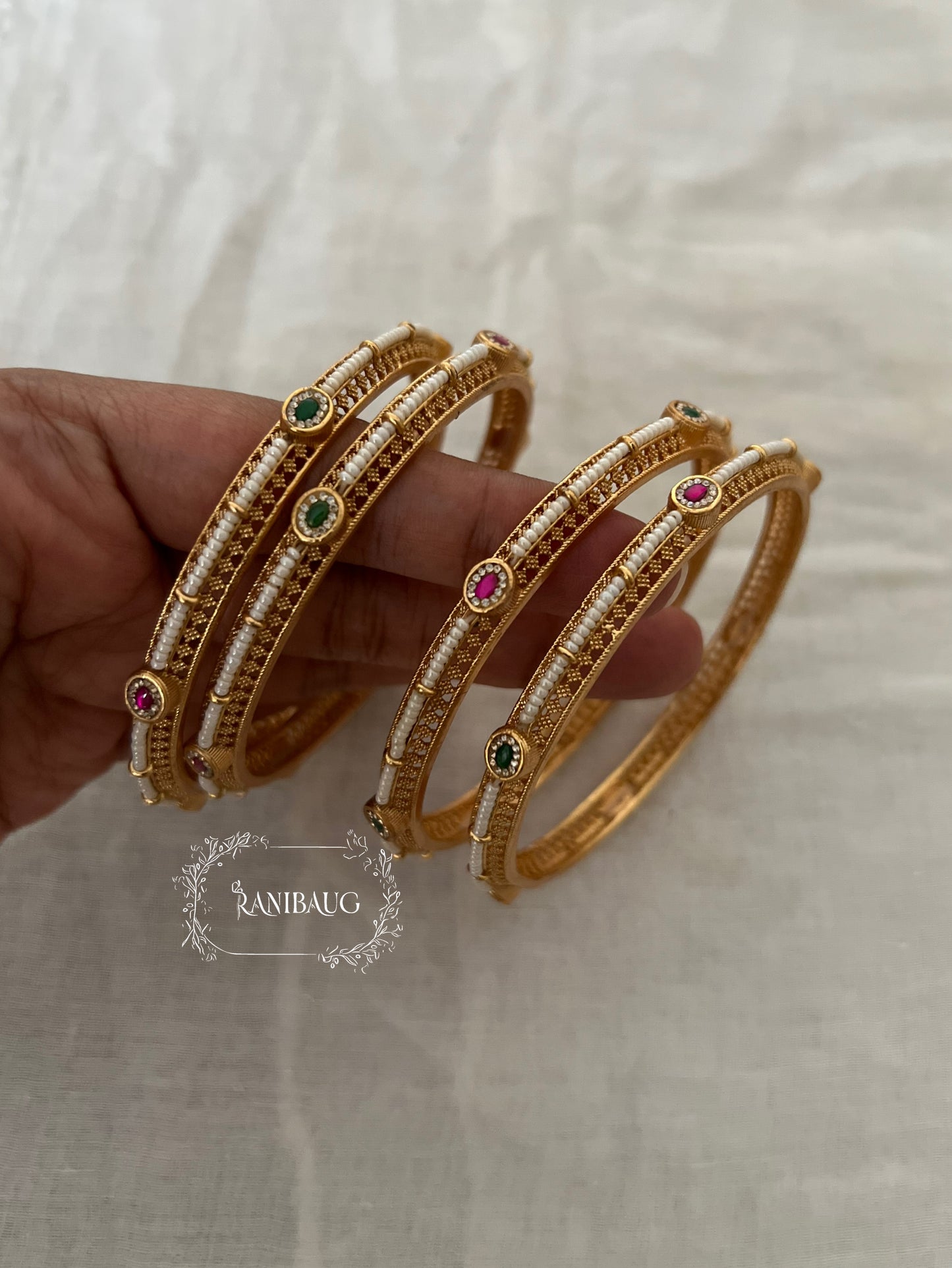Riddhima Pearl Beaded Intricate Designer Ruby Emerald Motif Gold Heritage Bangles By Ranibaug (set of 2)