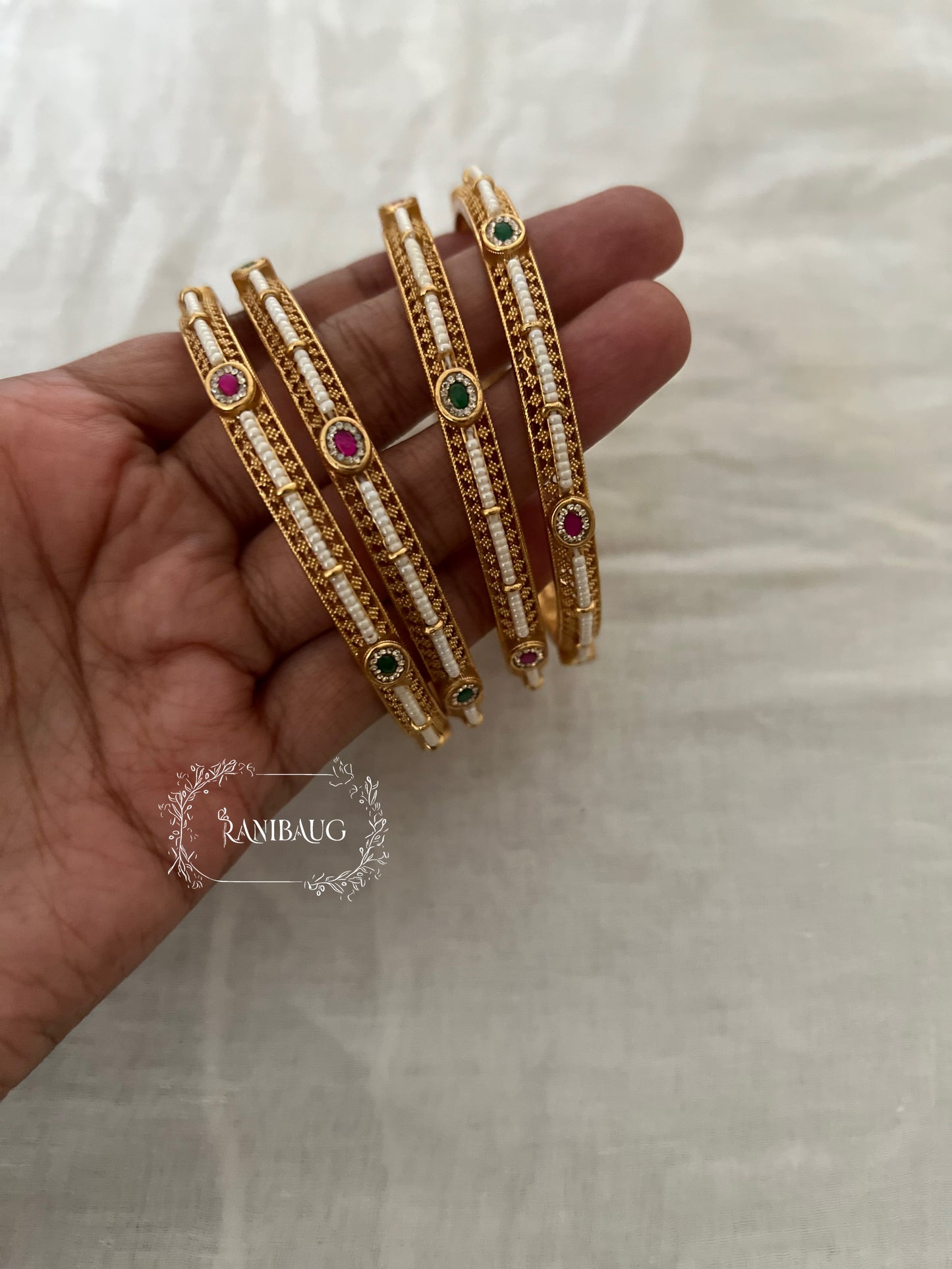 Riddhima Pearl Beaded Intricate Designer Ruby Emerald Motif Gold Heritage Bangles By Ranibaug (set of 2)