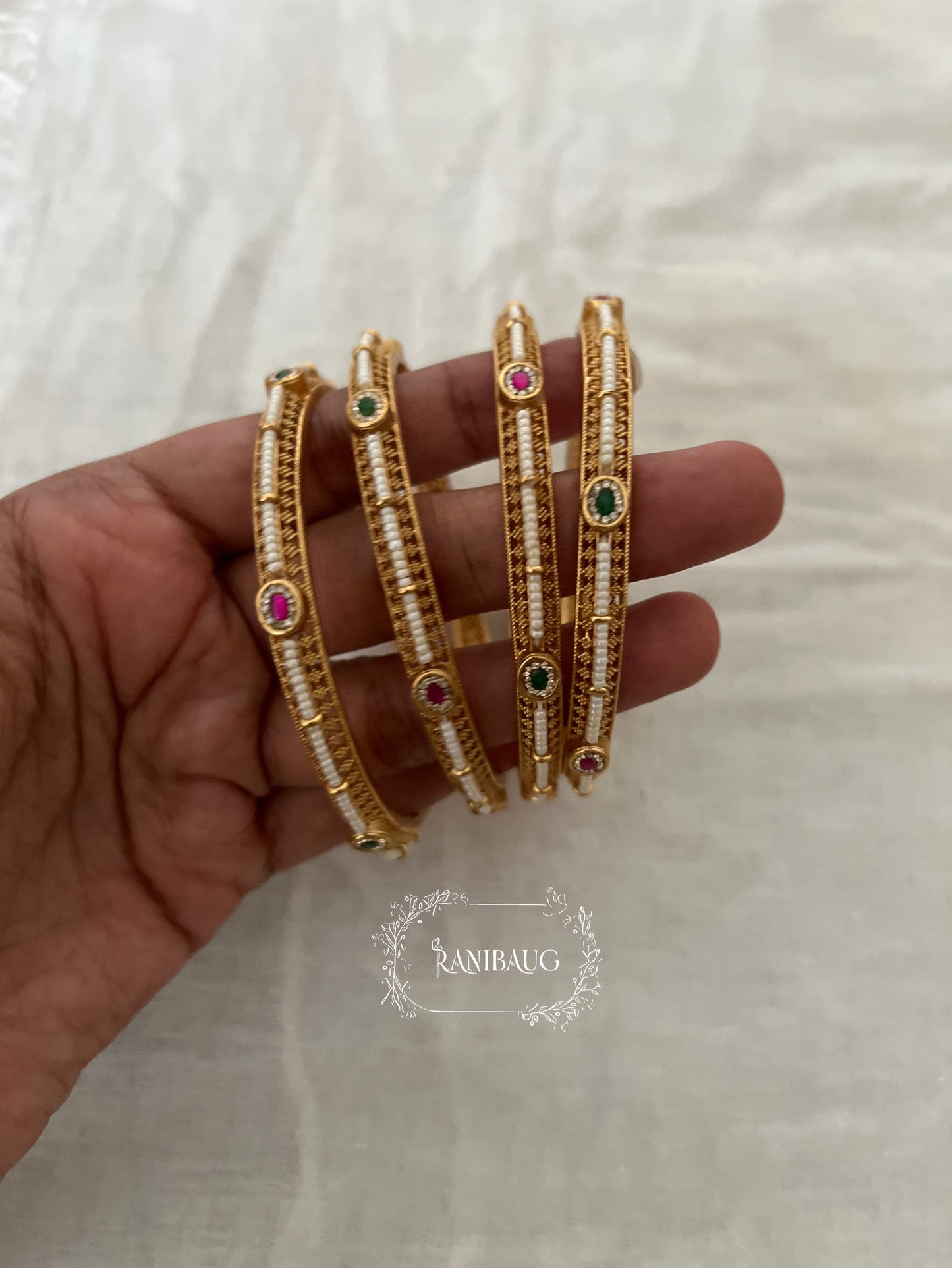 Riddhima Pearl Beaded Intricate Designer Ruby Emerald Motif Gold Heritage Bangles By Ranibaug (set of 2)