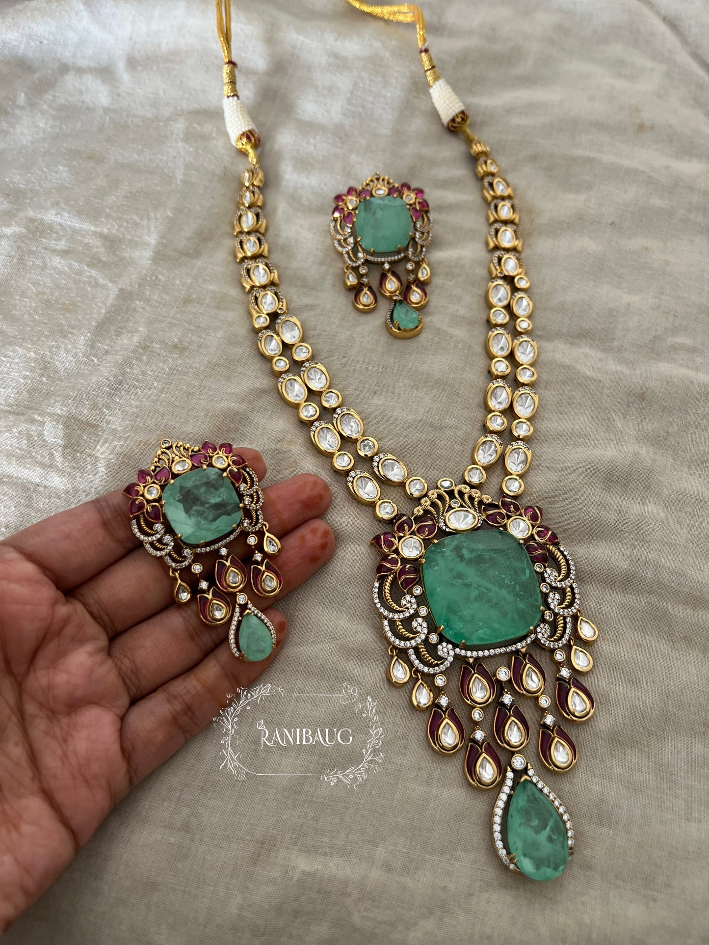Shreya Bold Long Adjustable Green Emerald And Kundan Necklace Set In Rich Gold Finish By Ranibaug
