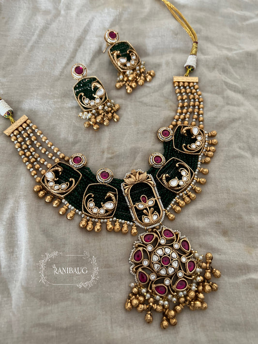 Shyama Gold Finish Peacock Motif Deep Green And Ruby Adorned Polki Heritage Jewellery Set By Ranibaug