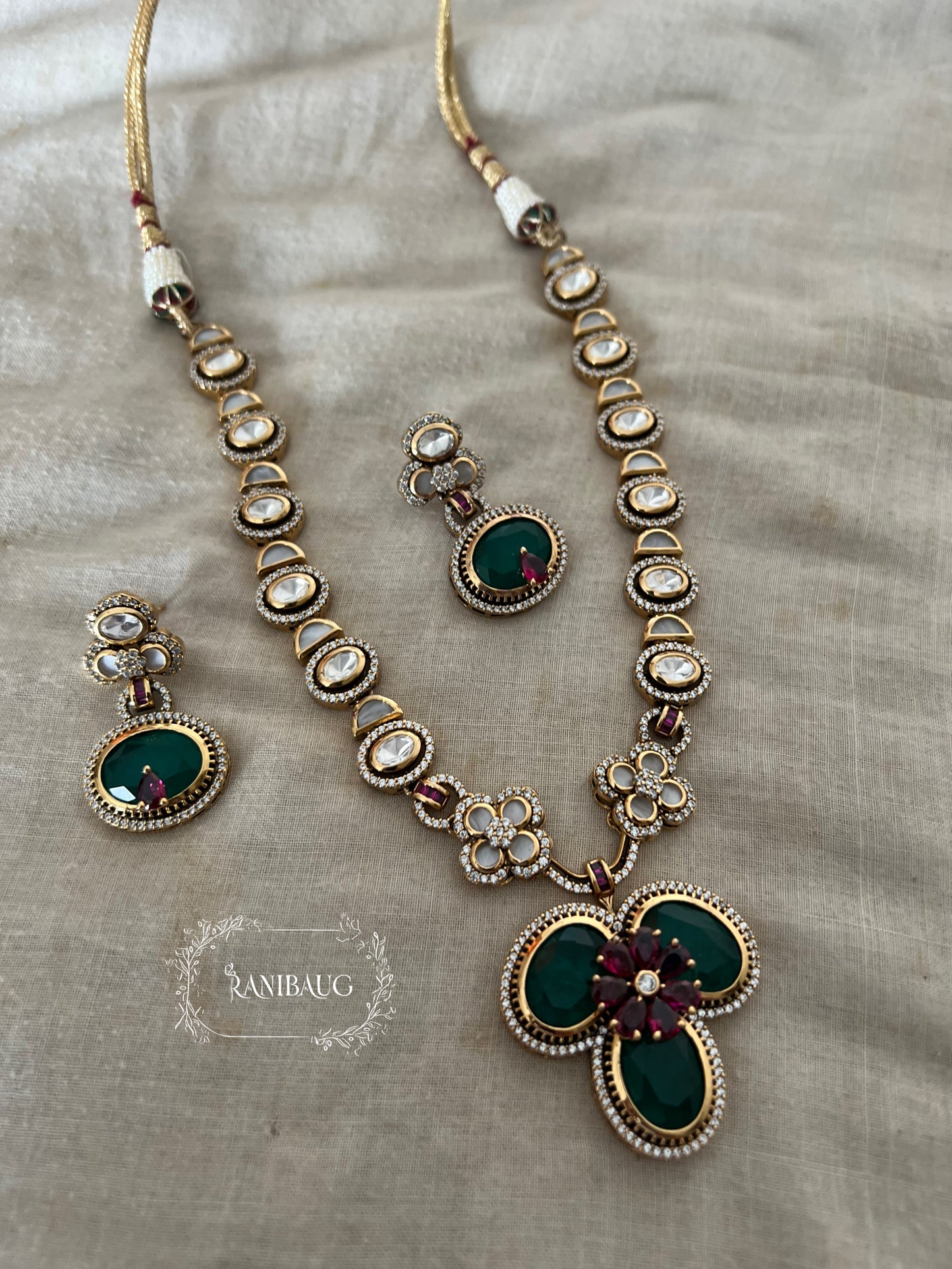 Verya Clover Leaf Inspired Emerald Ruby And Polki Adorned In Premium Gold Finish Designer Jewellery Set By Ranibaug